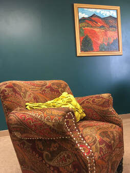 Photo of paisley chair in front of green wall with painting